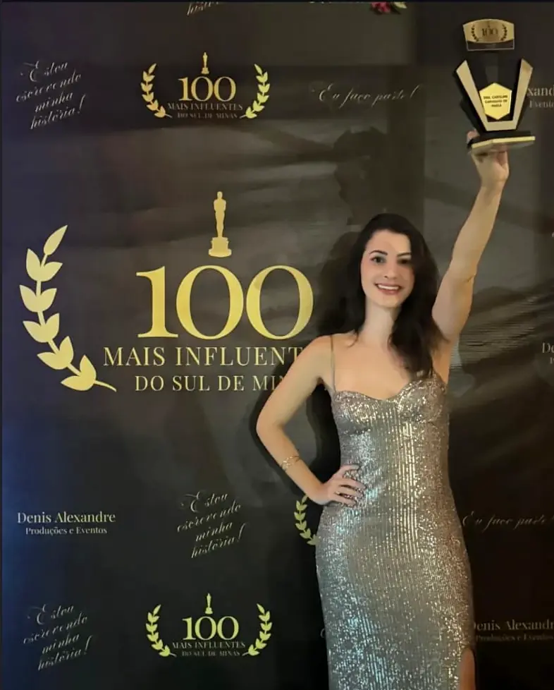 Dra. Caroline exibindo o troféu no tapete de honra