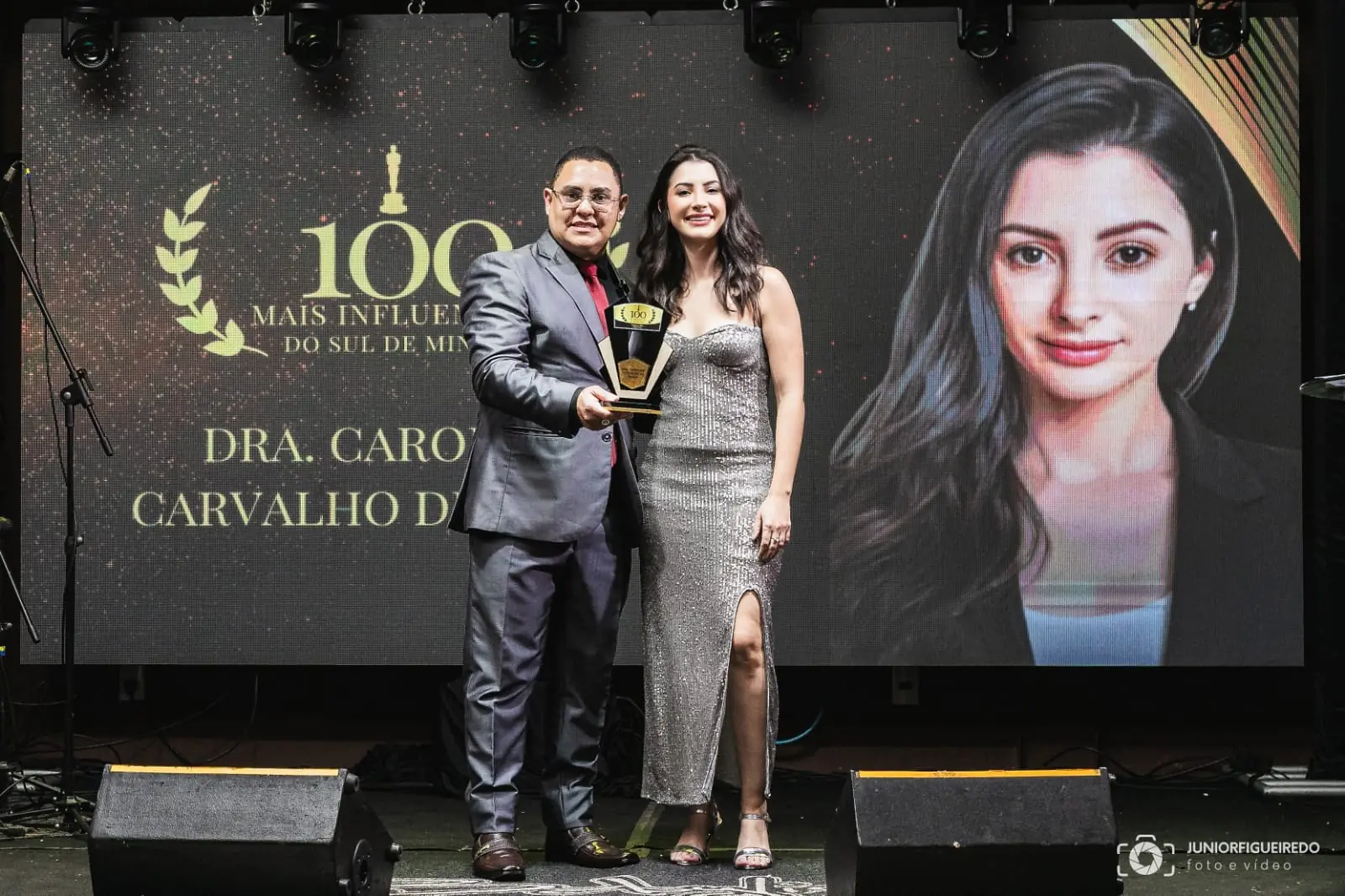 Dra. Caroline recebendo o troféu no palco